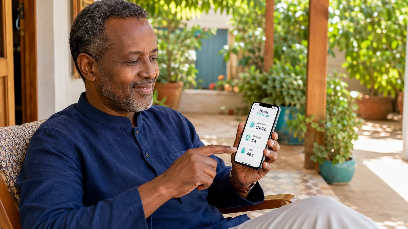 A Somali man on his veranda looking at his readings in the Hiraal Lifecare app.